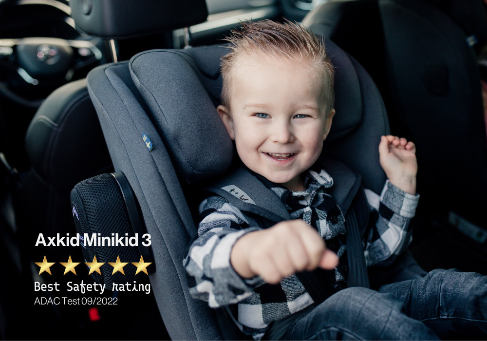 A boy is happy in car seat Axkid Minikid 3, which scored highest safety level at the ADAC crash tests.